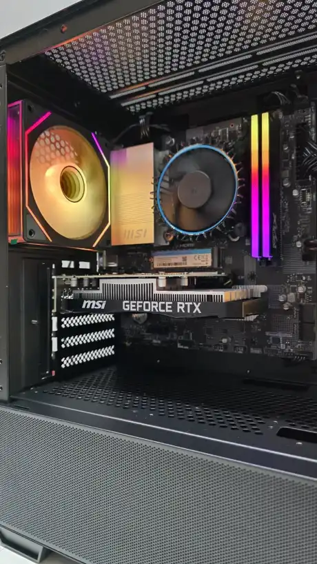 PC de lado na bancada, fans com luz laranja e placa de vídeo GeForce RTX