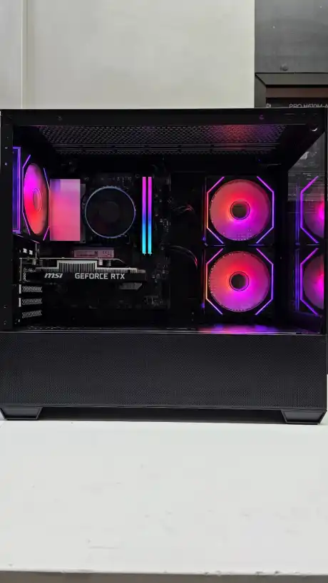 Gabinete preto de lado na bancada, fans em rosa e vermelho